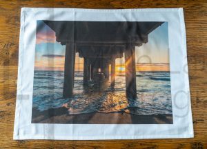 Seaford Beach tea towel unfolded on table.