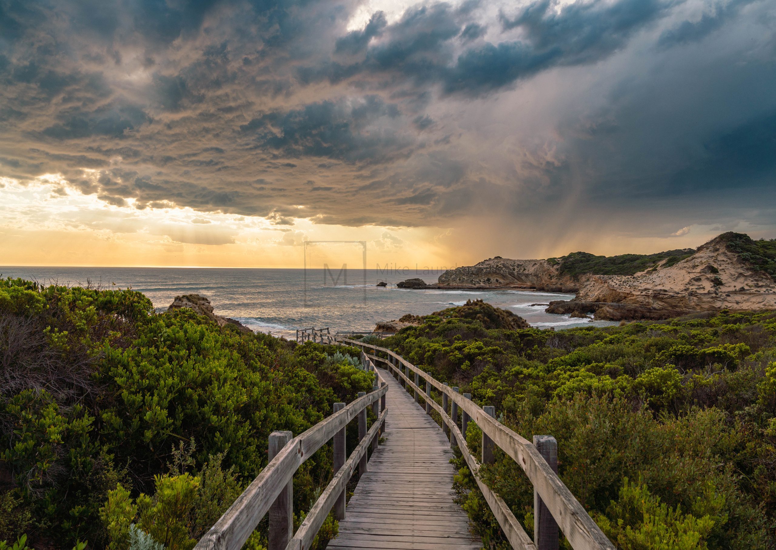 Boardwalk leading to ocean at sunset