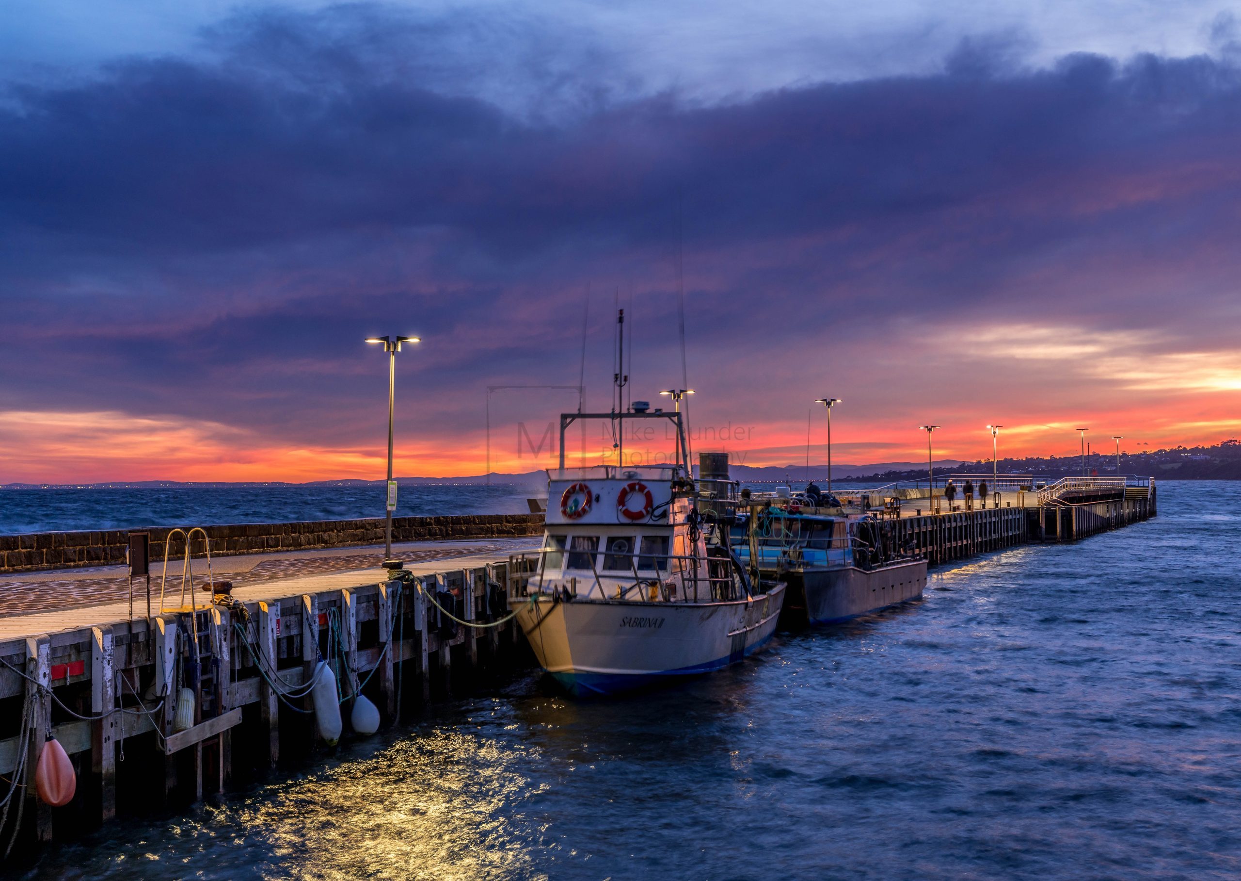 Boat moored at pier at sunrise